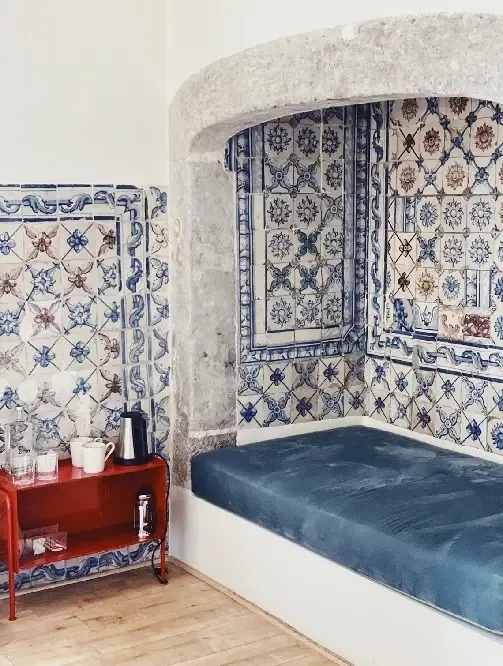 una habitación con una cama azul y azulejos en las paredes