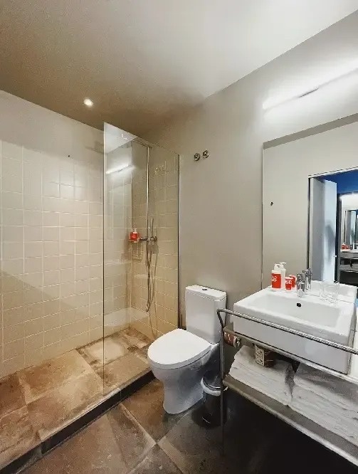 a bathroom with a toilet , sink and walk in shower .