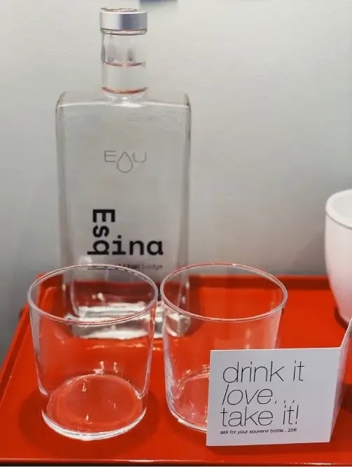 dos vasos y una botella de espina están sobre una bandeja roja