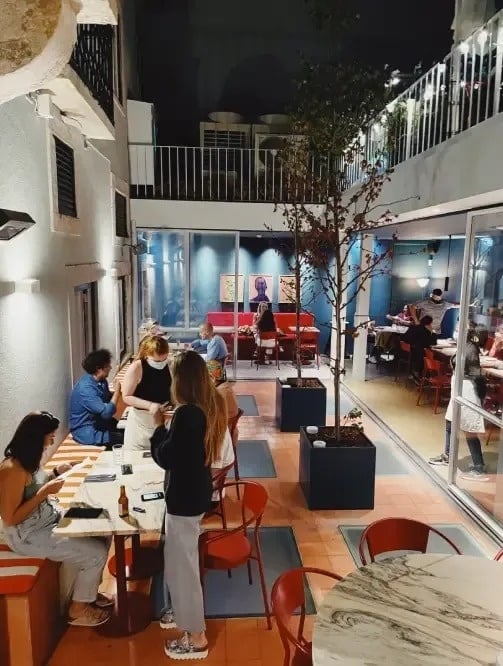 a group of people are sitting at tables in a restaurant