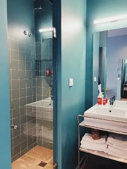 un baño con un lavabo y una ducha con una puerta de vidrio