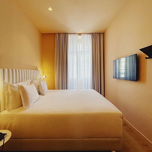 a bedroom with a large bed and a flat screen tv