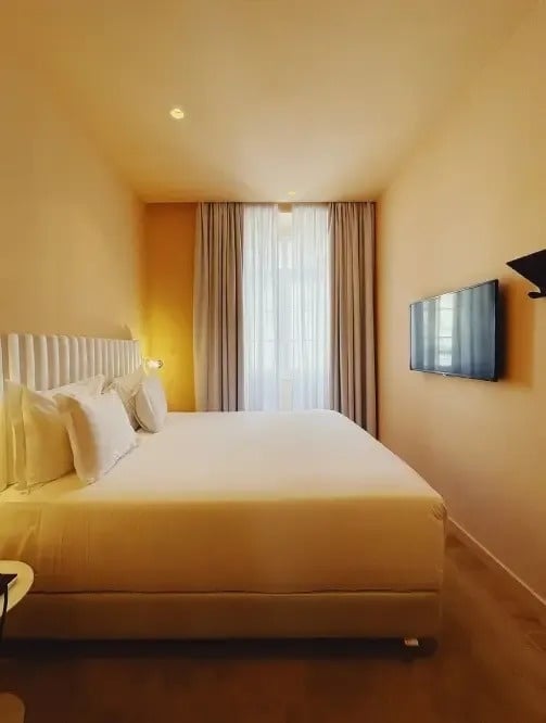 a hotel room with a king size bed and a flat screen tv on the wall .