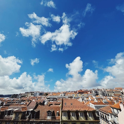 a cityscape with a blue sky and white clouds