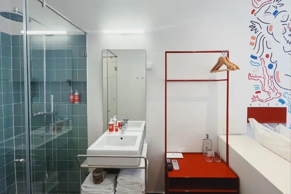 un baño con dos lavabos y una mesa roja