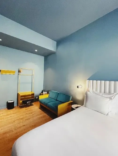 a hotel room with a bed and a blue couch
