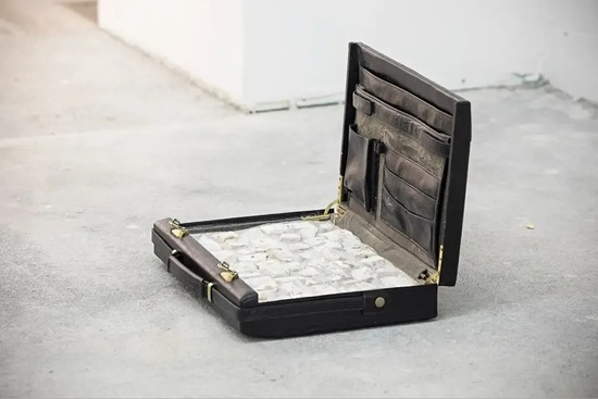 a black briefcase is sitting on a concrete floor