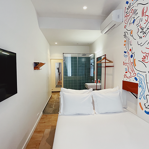 a bedroom with a painting on the wall and a bed