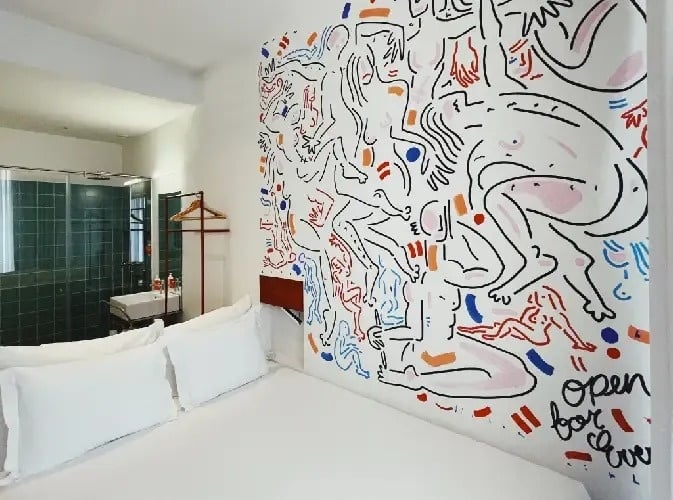 um quarto de hotel com uma cama e uma pintura na parede .