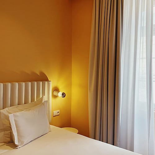 a hotel room with a bed and a window