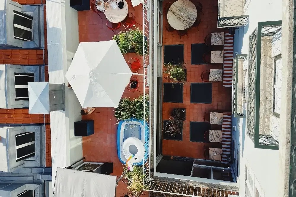 an aerial view of a balcony with tables and umbrellas