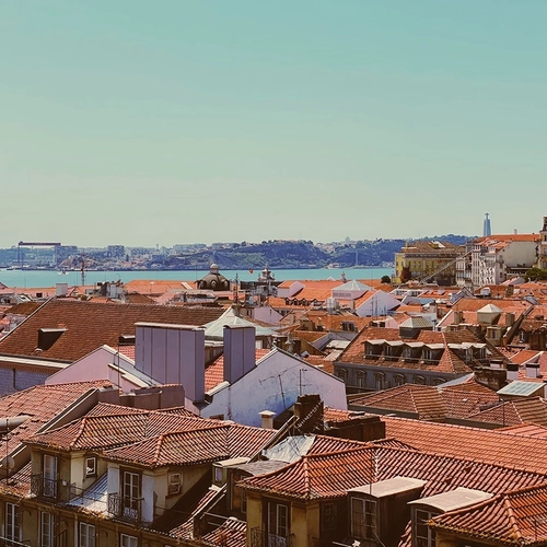 a rooftop view of a city with a body of water in the background