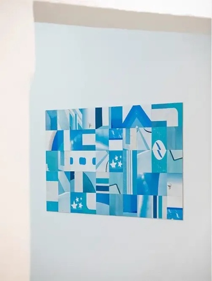 una pintura azul y blanca está colgada en una pared