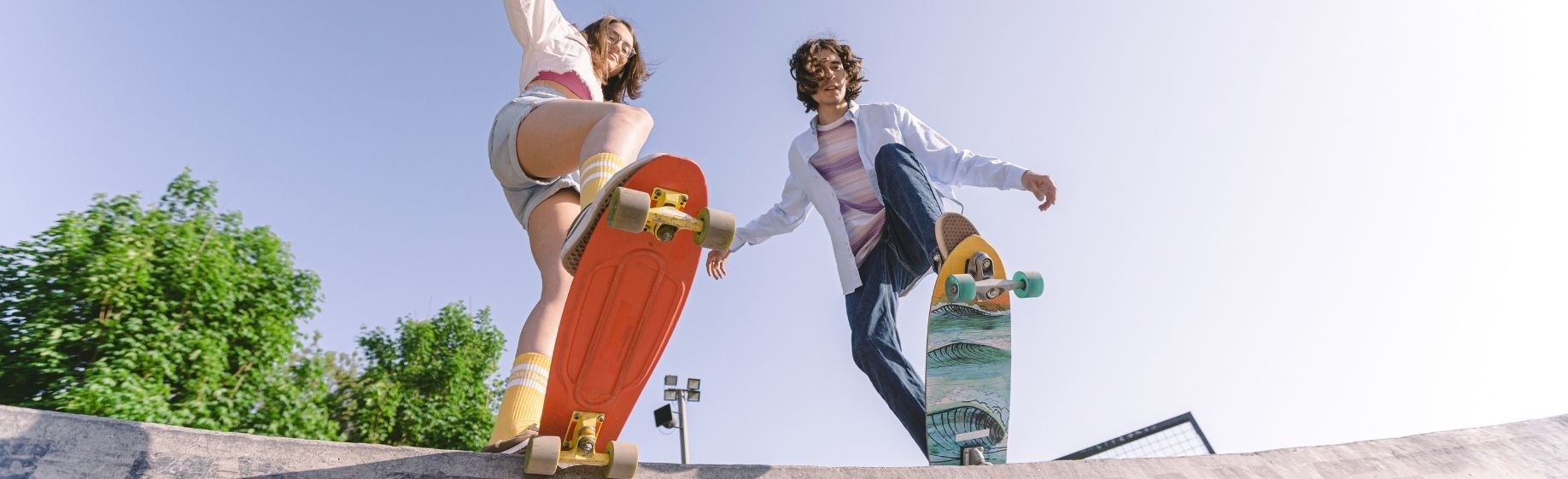 a man and a woman are holding hands while riding skateboards