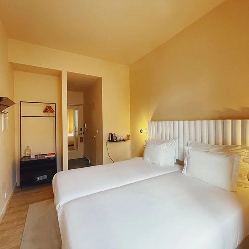 a hotel room with two beds and a flat screen tv