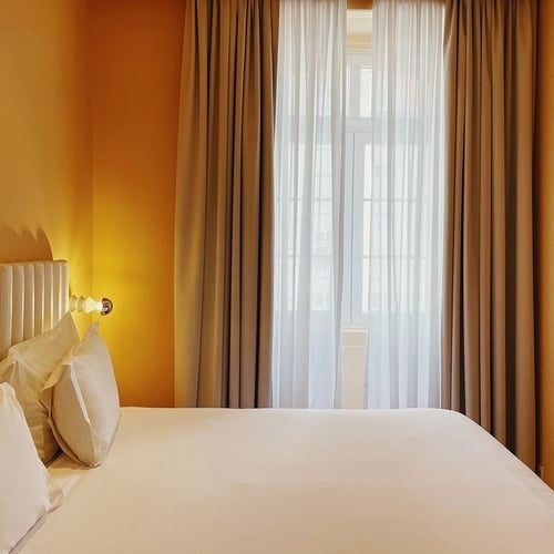 a bedroom with a bed and a window with curtains