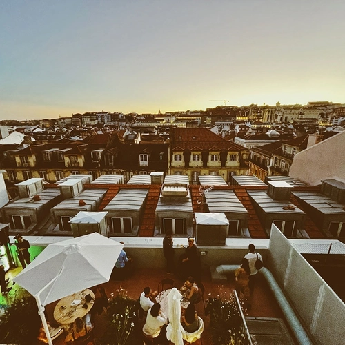 a group of people are gathered on a rooftop at sunset