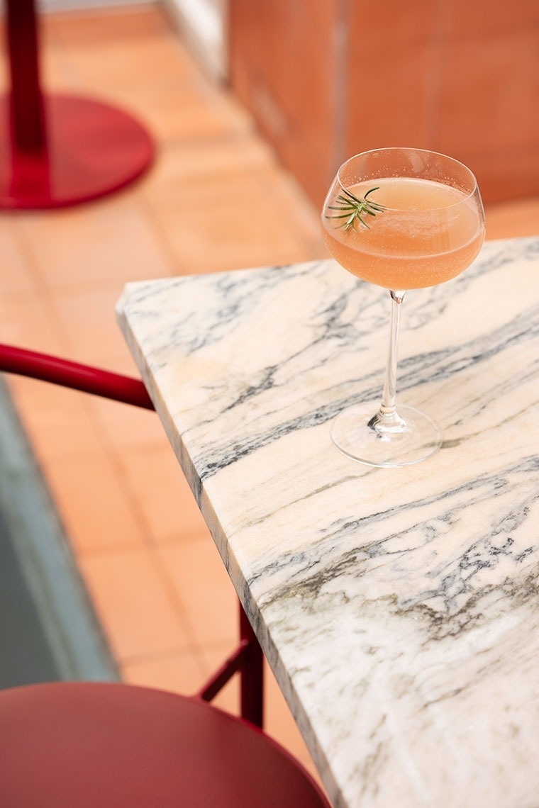 a drink in a coupe glass on a marble table