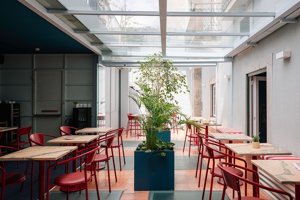 a restaurant with tables and chairs and a plant in the middle