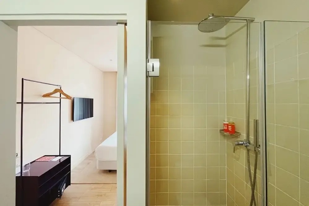 a bathroom with a shower and a tv on the wall