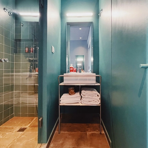 a bathroom with a sink and towels on a shelf