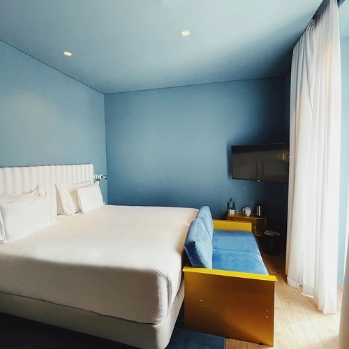 a hotel room with a bed and a yellow couch