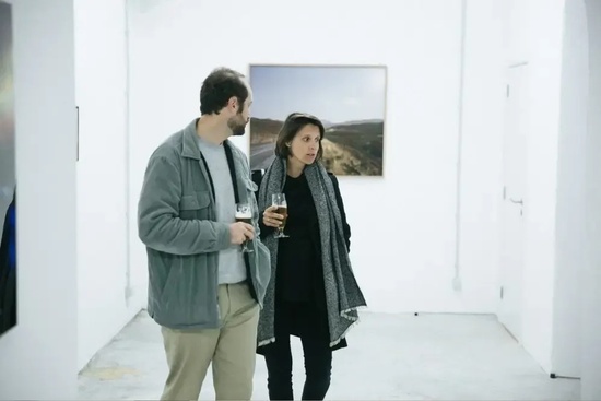 a man and a woman are looking at a picture in a gallery