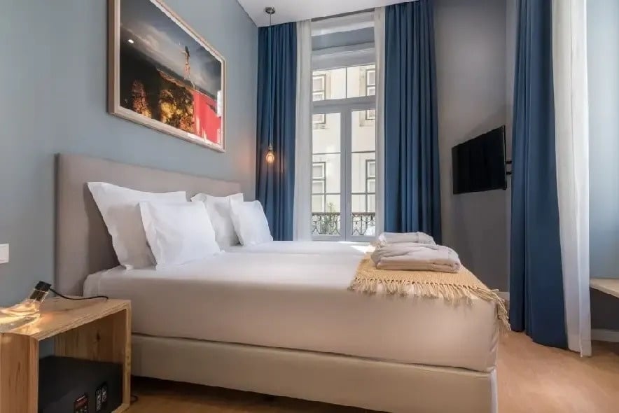 um quarto de hotel com duas camas e uma televisão
