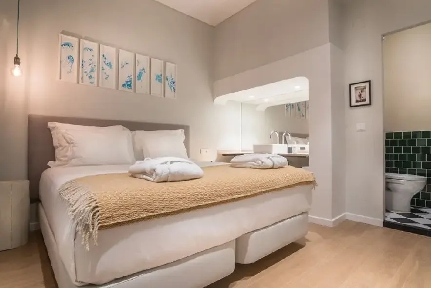 un dormitorio con una cama y un baño con azulejos verdes