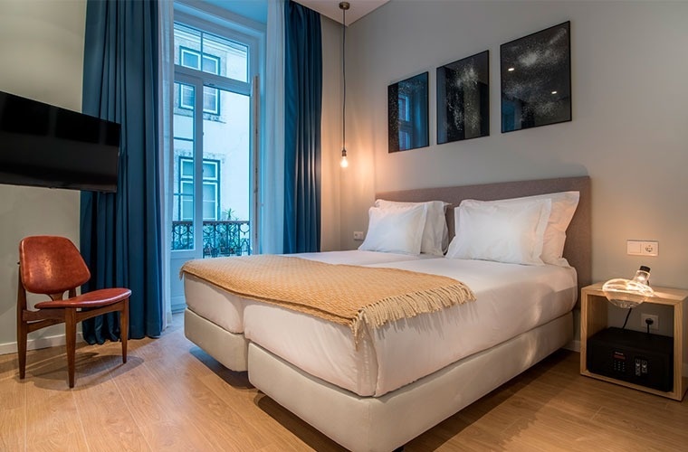 a hotel room with a bed , chair and television .