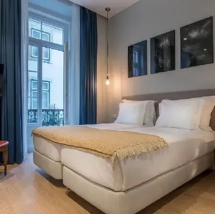 a hotel room with two beds and a large window .