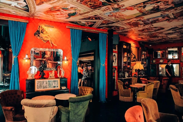Elegant hotel lounge with unique ceiling art and plush seating. Esqina Urban Lodge