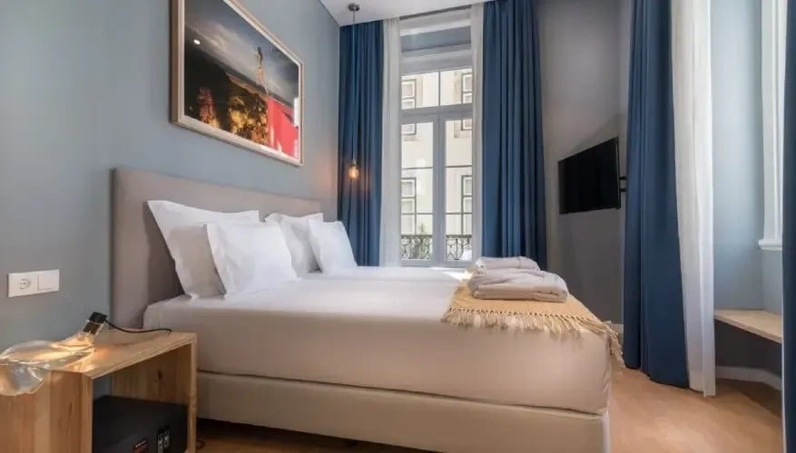 um quarto de hotel com duas camas , uma televisão e uma janela .