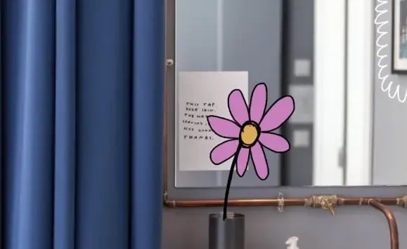 a purple flower is sitting in front of a mirror with a note on it .