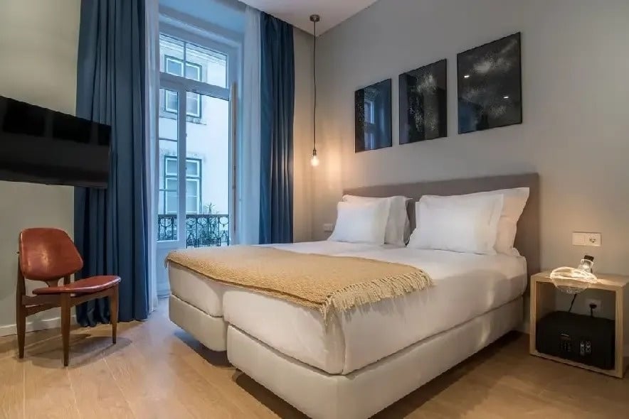 um quarto de hotel com cama , cadeira e televisão .