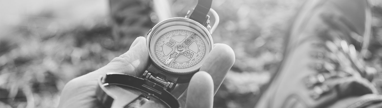 a black and white photo of a person holding a compass