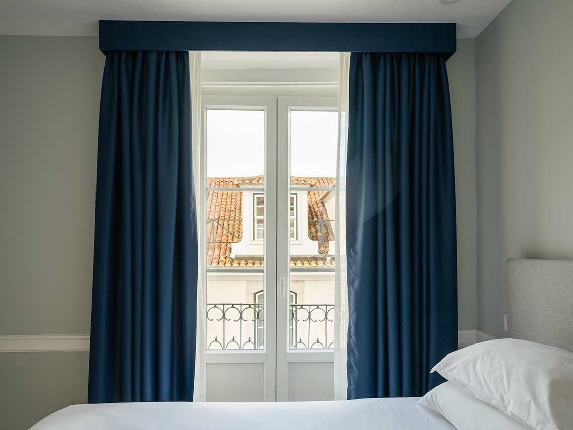 un dormitorio con una cama y un baño con azulejos verdes