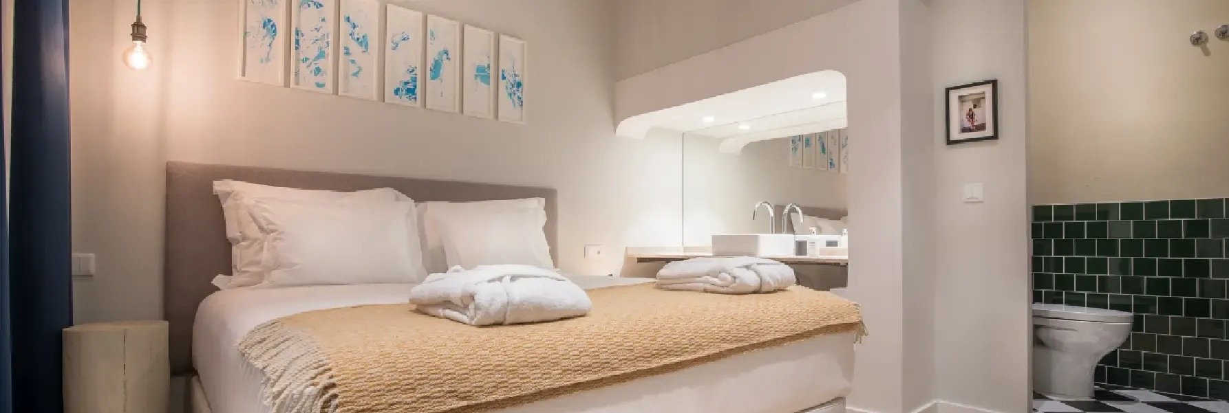 una habitación con una cama y un baño con azulejos verdes