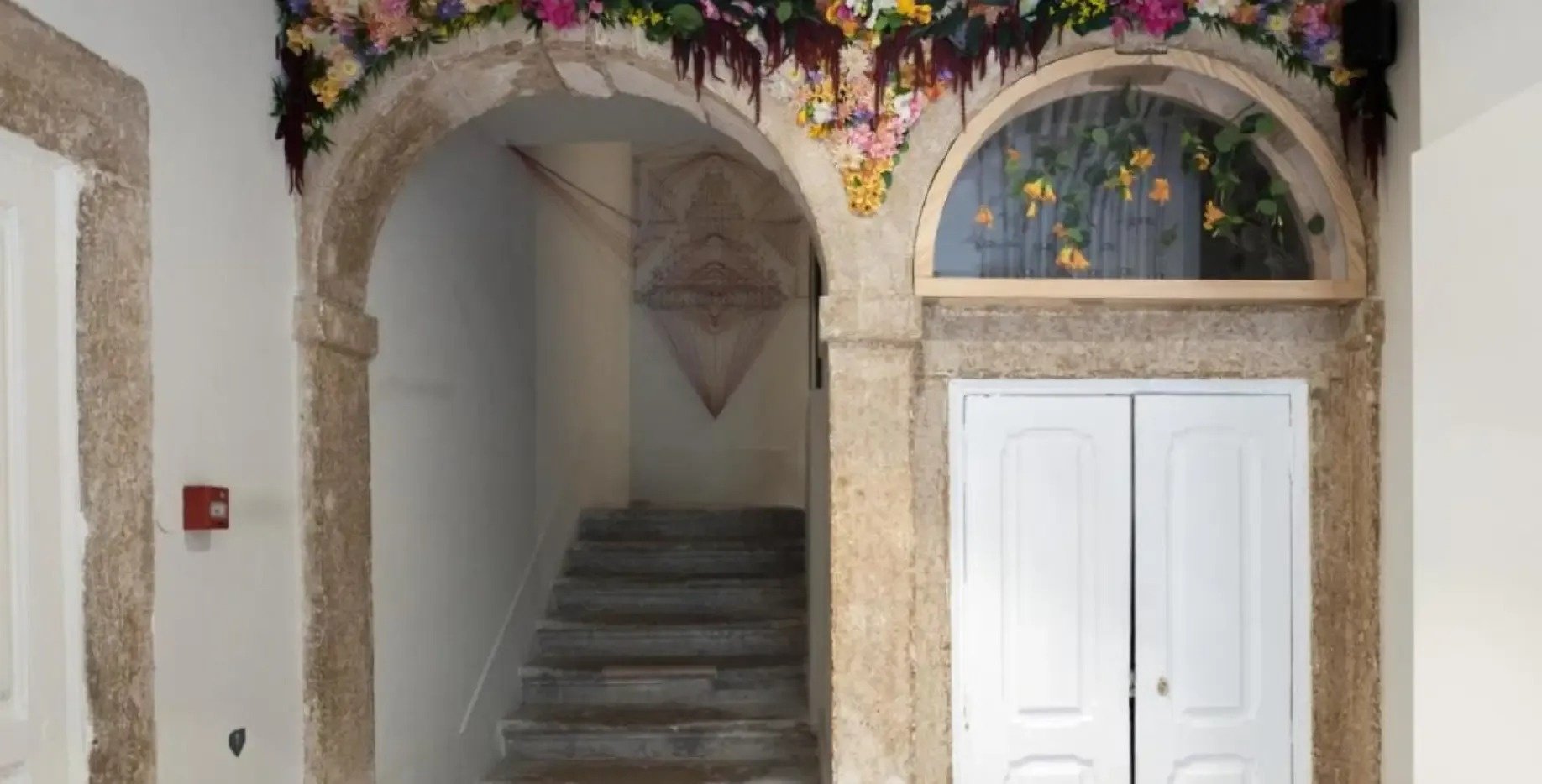 uma porta branca e uma escada com flores ao redor