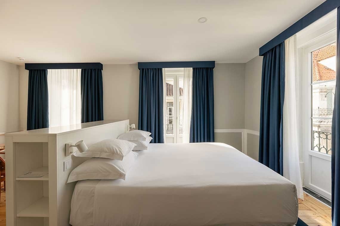 una habitación con una cama y un inodoro junto a una ventana