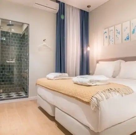 um quarto com cama , chuveiro e cortinas azuis .