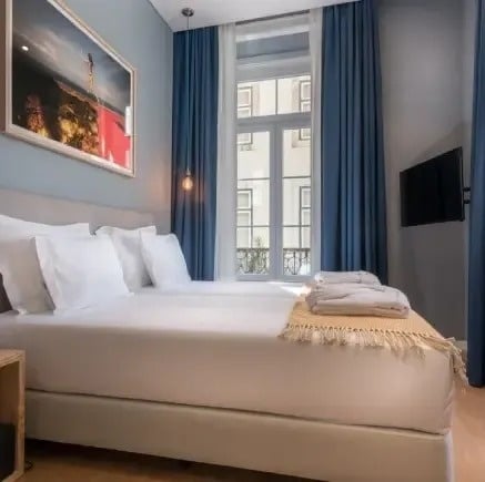 um quarto de hotel com cama , televisão e janela .