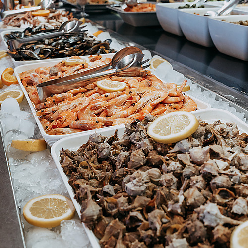 Buffet display of fresh seafood, including shrimp and mussels, with lemon wedges and ice. ESTIVAL: D Altafulla