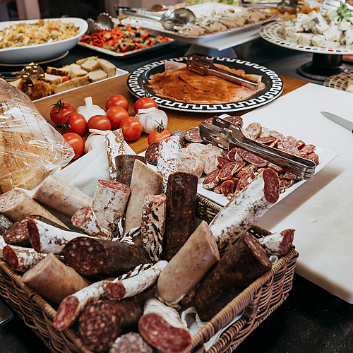 Assortment of cured meats, bread, tomatoes, and garlic at a ESTIVAL: D Altafulla buffet.