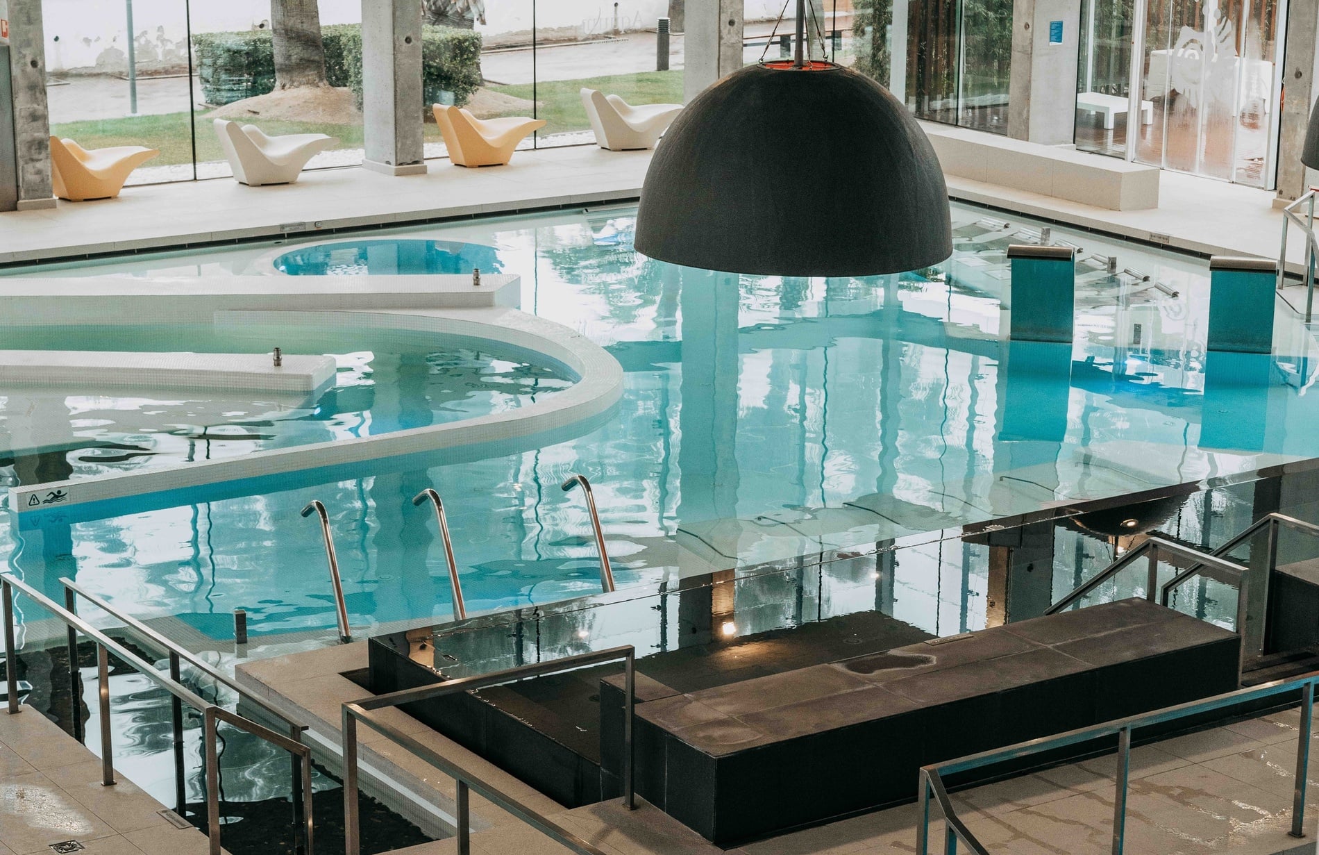 une piscine intérieure avec des escaliers et une cascade