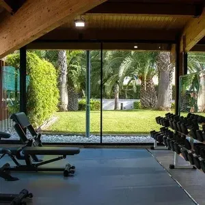 Gimnasio interior con vistas tropicales en ESTIVAL: Oassium Hotel.