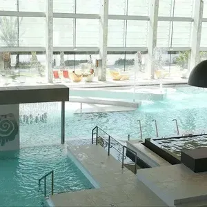 Piscina interior del ESTIVAL: Oassium Hotel, con cascadas y tumbonas.