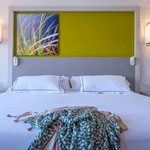 Habitación moderna en ESTIVAL: Oassium Hotel, con cama confortable y arte abstracto.