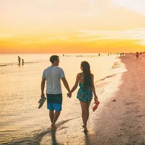 Pareja paseando por la playa al atardecer, ESTIVAL: Oassium Hotel.