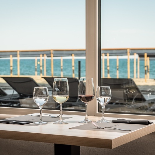 tres copas de vino están sobre una mesa frente a una ventana
